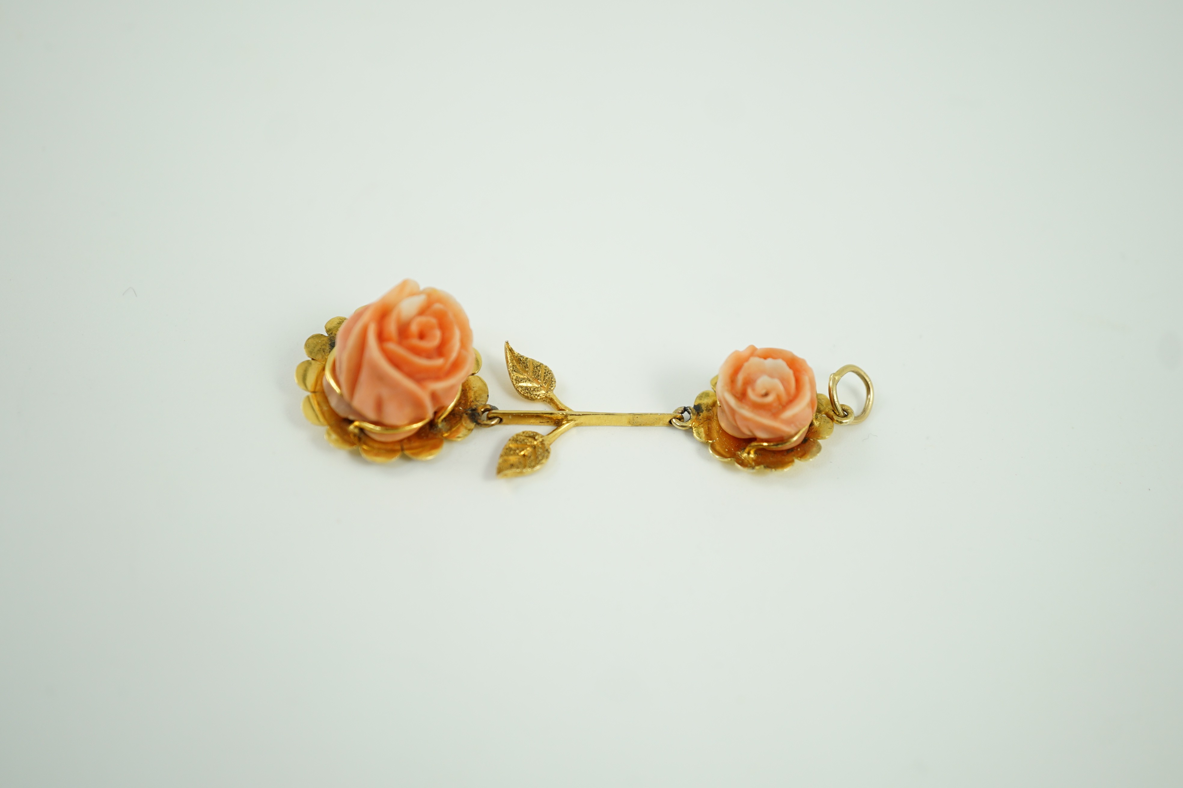 A yellow metal and two stone carved coral set 'rose' drop pendant, overall 57mm, gross weight 6 grams.